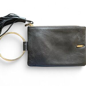 THACKER Nolita ring handle leather clutch in black. Long leather tassel attached
